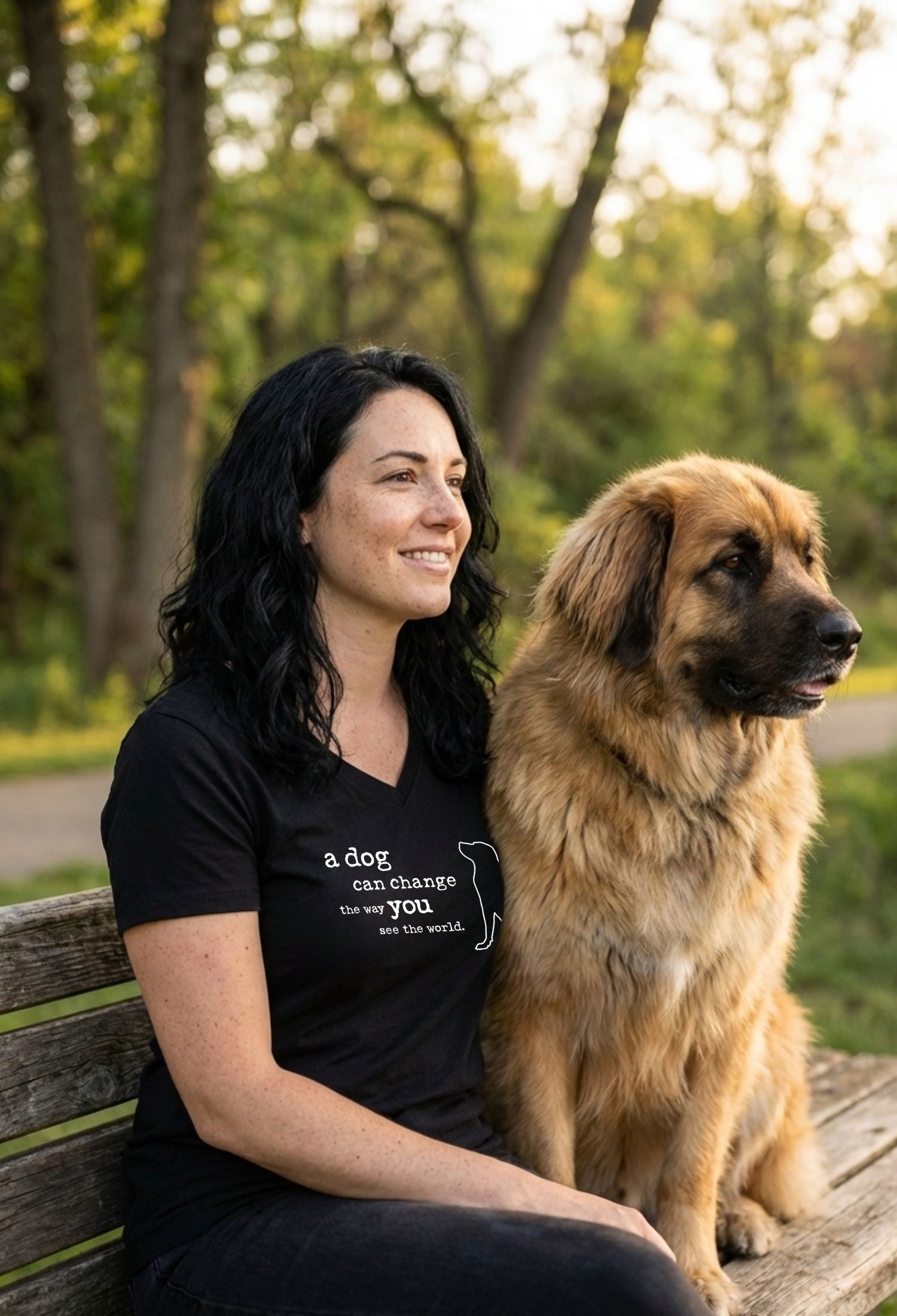Woman sitting on a bench with a dog in a park